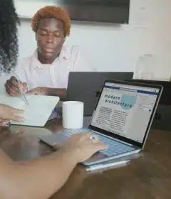 Three people meeting with their Microsoft devices at work